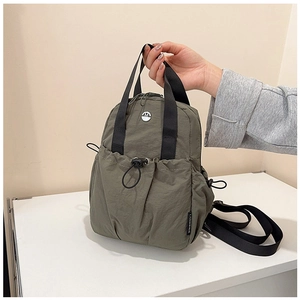 Detail view of olive green nylon bag with drawstring pocket and reinforced top handle