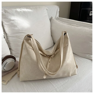 Detail of soft cream PU leather tote bag with subtle texture and gold-tone hardware