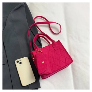 Detailansicht der gesteppten magentafarbenen Stofftasche mit passender kleiner Tasche und Kette