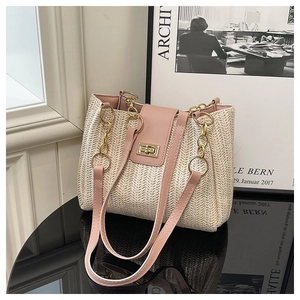 Detail of woven straw tote featuring pink faux leather flap and gold twist lock closure
