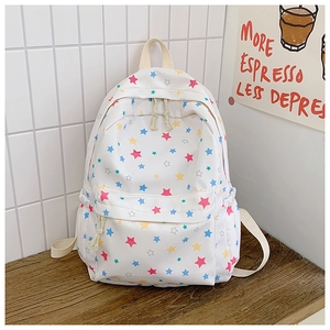Detail view of cream canvas backpack featuring multi-color star prints and side pocket