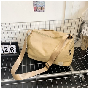 Detailed view of khaki nylon bucket bag with adjustable strap and logo on metal rack