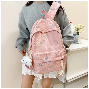 Pink quilted backpack for students featuring colorful embroidered bows and cloud pendant