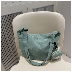 Detailed view of mint green corduroy tote bag with small round coin purse and fashion label