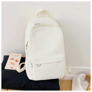 Close-up of minimalist white canvas backpack with small geometric icons and metal ring zip