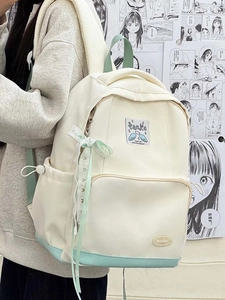 Side view of beige and mint green school backpack with ribbon and tanke brand label