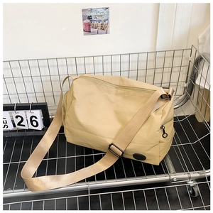 Detail shot of khaki nylon bucket bag with adjustable wide strap in a metal cart