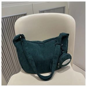 Detailed close-up of dark green corduroy crescent bag with matching round coin purse