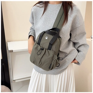 Detail of army green nylon crossbody bag with drawstring pocket and sturdy handle