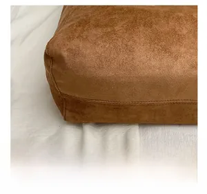 Macro view of precise stitching on the brown suede tote bag base showing fine craftsmanship