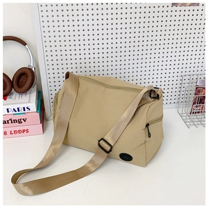 Detail shot of khaki nylon bucket bag showing side zipper and adjustable wide strap