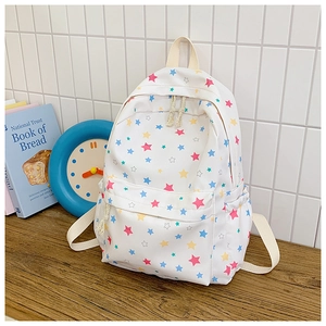 Detail of white canvas backpack with multi-color star patterns and side pocket features