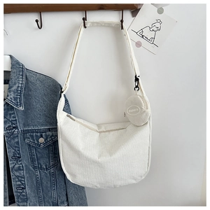 Close-up of a white corduroy Hobo bag detail with a round FASHION coin purse charm