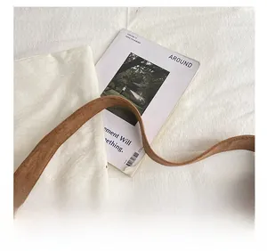 Detail of wide shoulder strap on brown leopard print suede tote bag for women
