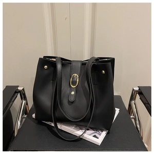 Macro detail of black leather tote bag with golden buckle and metal rivet accents