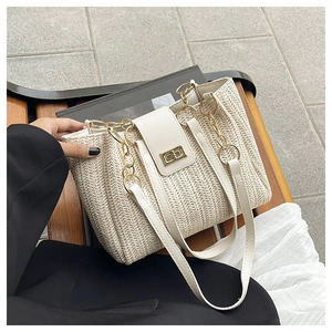 Close-up of beige woven tote bag featuring white leather flap and gold twist lock closure