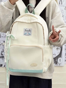 Close-up of mint green lace ribbon and brand label on a beige canvas backpack