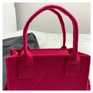Nahaufnahme des gesteppten Rautenmusters auf der rosaroten Filz-Schultertasche