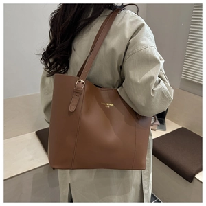 Detail of adjustable metal buckle and gold printed logo on large dark brown tote bag