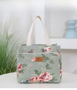 Detailed view of sage green floral canvas tote bag with pink roses and leather logo patch