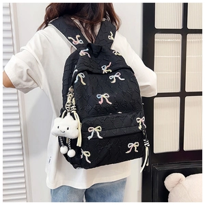 Rear view of black quilted backpack with colorful butterfly embroidery and cloud charm