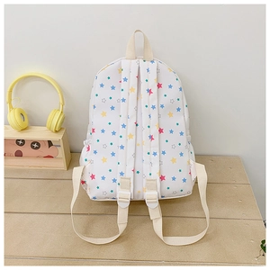 Close-up of the back of white canvas backpack featuring colorful star patterns