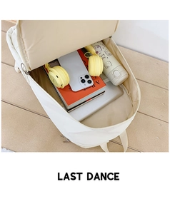 Internal view of a spacious white canvas backpack showing books and laptop storage