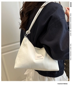 Détail du sac à bandoulière blanc plissé avec texture gaufrée et anneaux métalliques