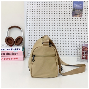 Detail view of khaki nylon bucket bag with side zipper pocket and adjustable strap