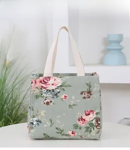 Detail of floral canvas bento bag featuring rose patterns and cotton top handles