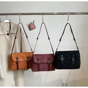Detailed close-up of retro suede crossbody bags in brown, burgundy, and black colors