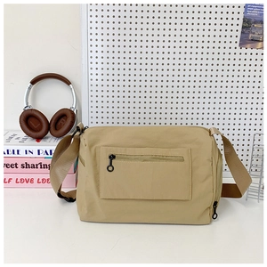 Detail of khaki nylon messenger bag with wide shoulder strap and side zipper pocket