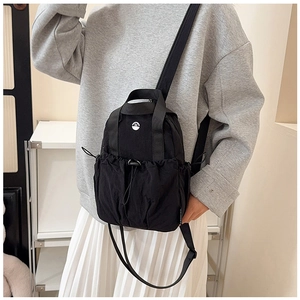 Detail of black waterproof nylon mini backpack with drawstring pocket and white M logo