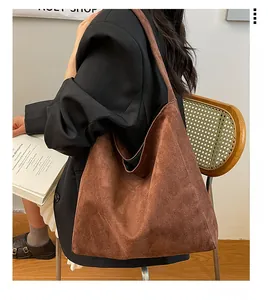 Detail view of a large brown faux suede tote bag with hobo silhouette and matte finish texture