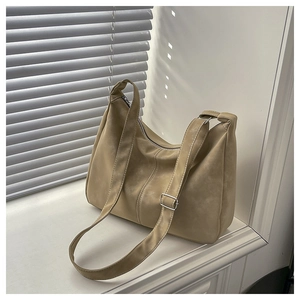 Detail view of khaki suede crescent hobo bag with silver zipper and adjustable strap