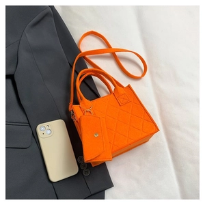 Detailansicht eines orangefarbenen Stepp-Tote-Bag-Sets mit kleiner Tasche und Gurt