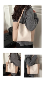 Detail of color-block tote bag with gold lettering and adjustable long shoulder strap