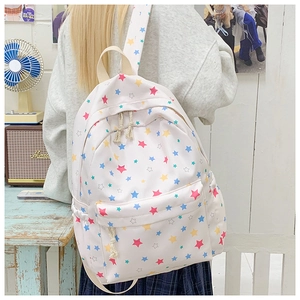 Detail view of white nylon backpack with colorful star prints and knotted zipper puller