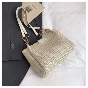 Detail of cream woven tote bag featuring fine V-texture and gold chain leather strap