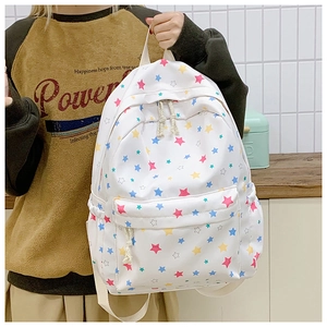Detail view of colorful star print on white canvas backpack with rope zipper pulls