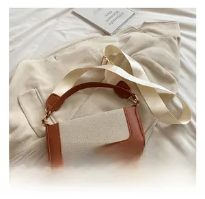 Detail of retro color-block handbag showing brown leather and cream canvas textures