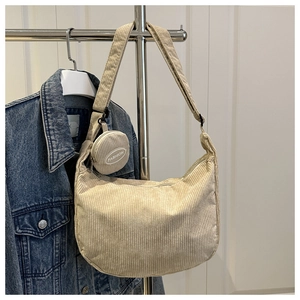 Detail of beige corduroy hobo bag with a matching round mini coin purse pendant