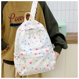 Detailed side view of white canvas backpack featuring colorful star patterns on a model