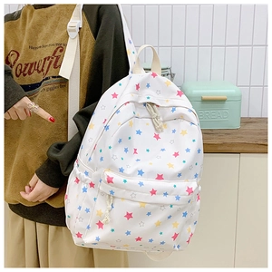 Detail view of white backpack with colorful star pattern and smooth zipper closure
