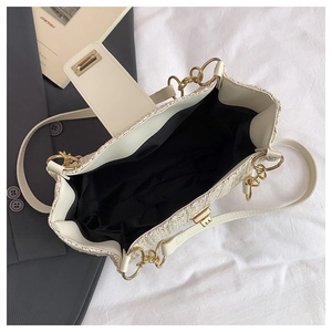 Top view of cream woven tote bag with gold metal buckle and spacious interior liner