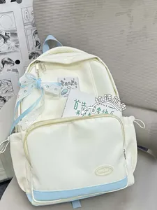 Detail view of canvas backpack with lace bow decor and double front zipper pockets
