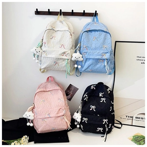 Macro detail of nylon striped backpacks in four colors with cute bow embroidery