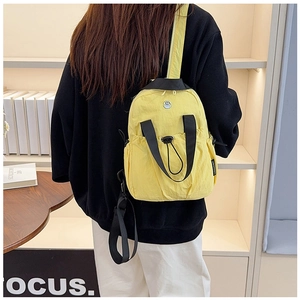Detail view of lightweight lemon yellow nylon backpack featuring adjustable black straps