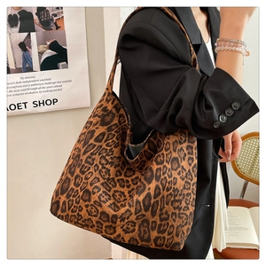 Close-up of leopard print faux suede tote bag on shoulder with classic brown patterns
