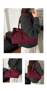 Detail of burgundy faux suede tote bag featuring polished leather trim and metal buckle